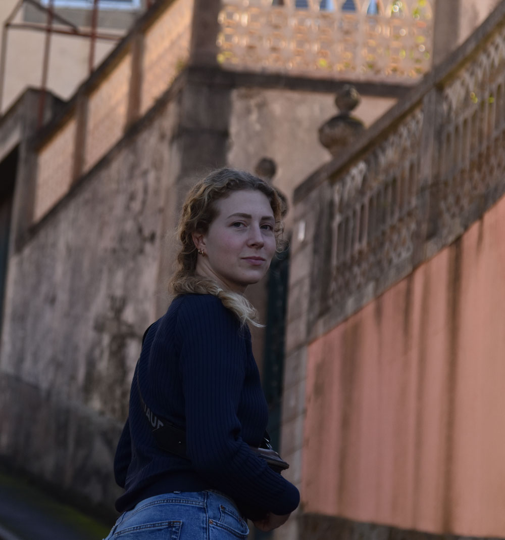 Celine Wempe glancing back over her shoulder at the camera, with a slight smile and a thoughtful expression, creating a sense of intrigue and connection.