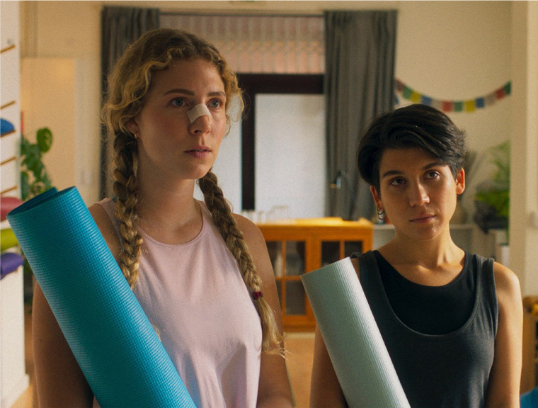 Celine Wempe in 'La Práctica' (2023), sitting next to her friend in a yoga class with a bandage over her nose, indicating a recent injury.